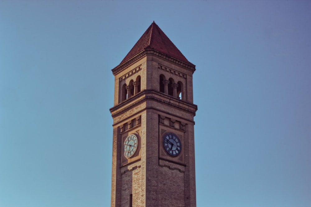 un'alta torre dell'orologio con un orologio su ciascuno dei suoi lati