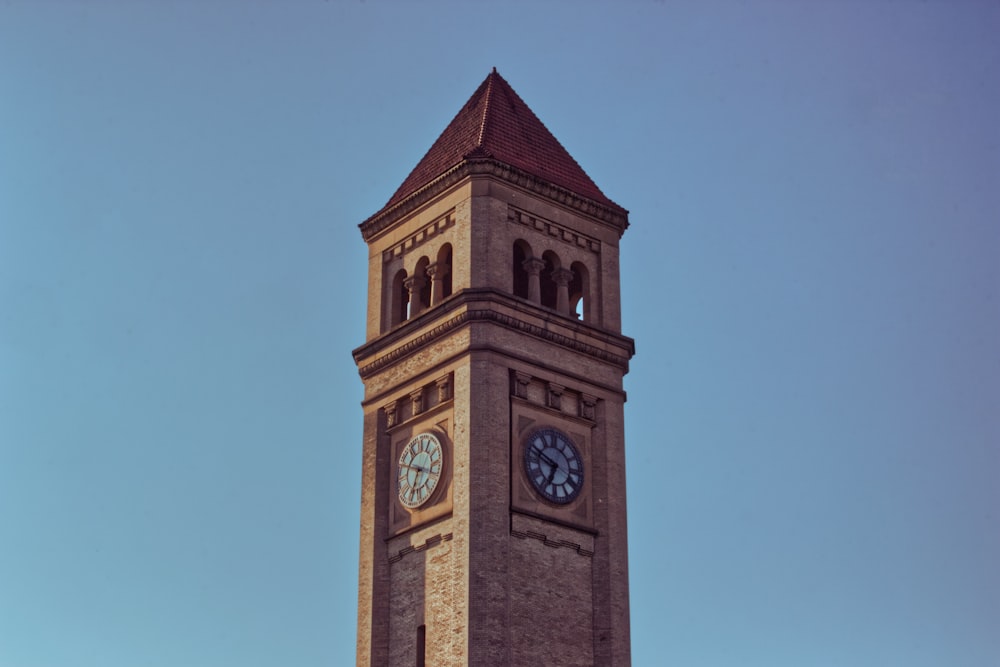 uma torre de relógio alta com um relógio em cada um de seus lados