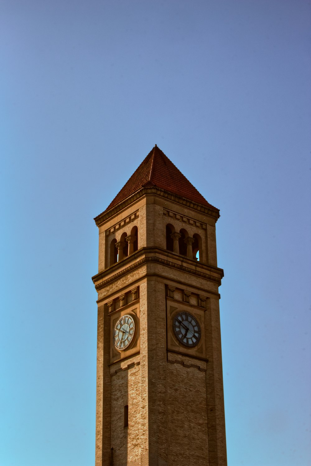 ein hoher Glockenturm mit einer Uhr auf jeder Seite