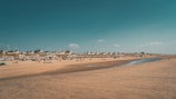 A clean beach with people enjoying the sun.