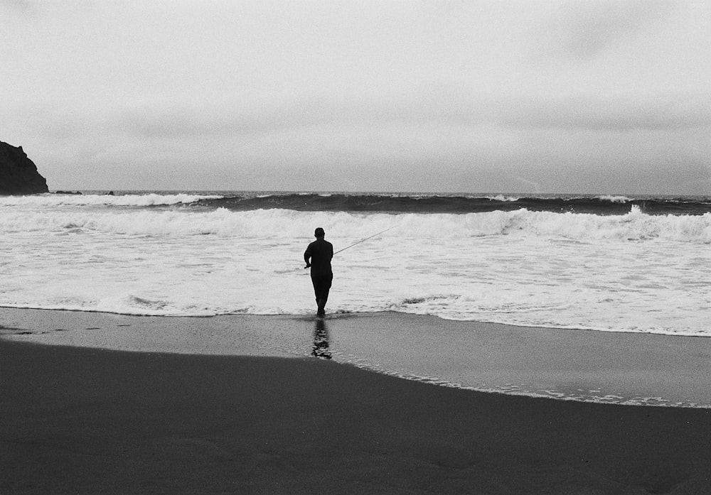 a person standing on a beach next to the ocean