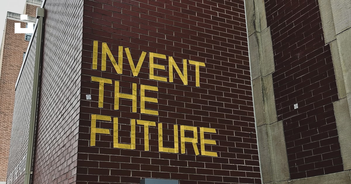 A brick building with a sign that says invent the future photo – Free ...
