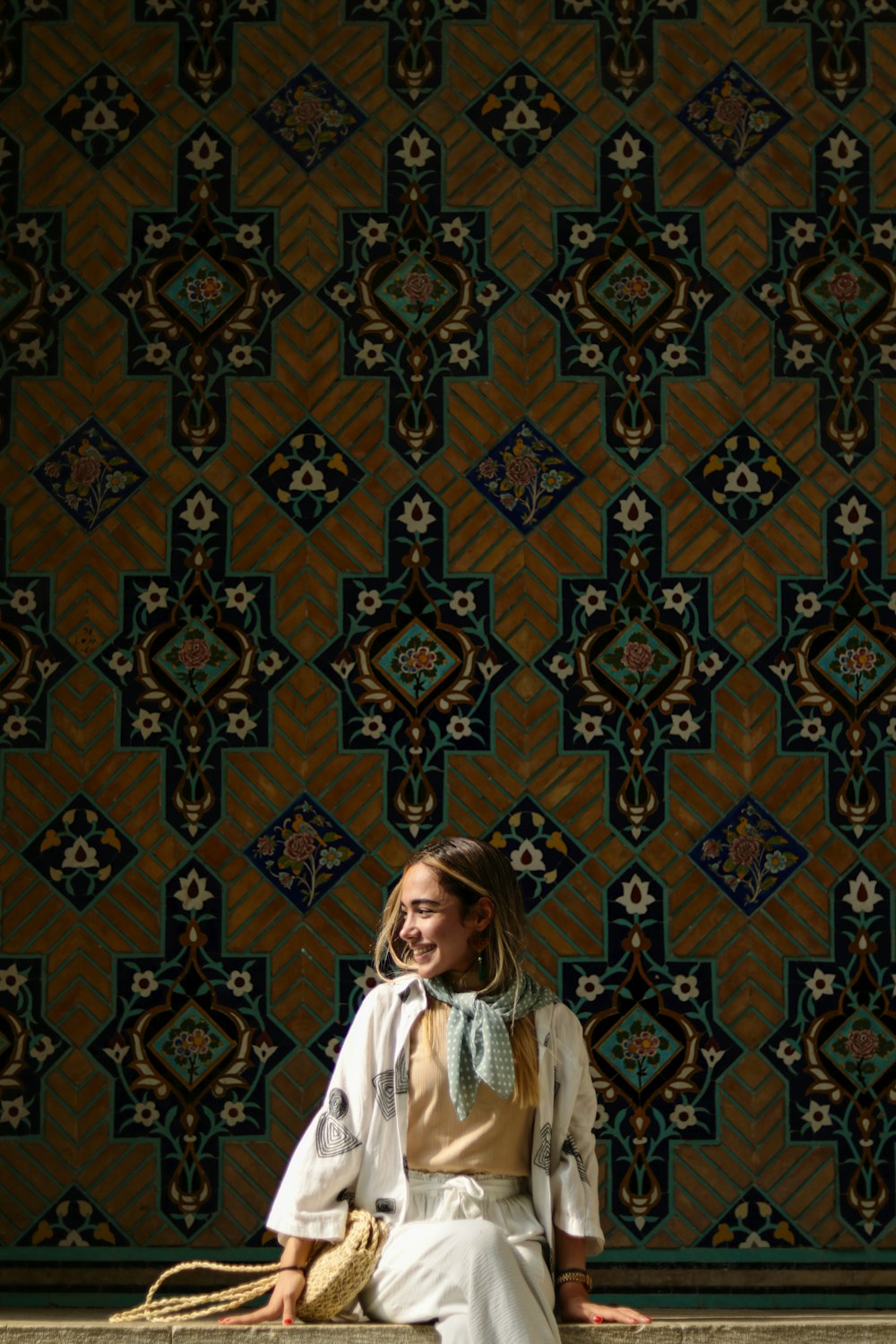 uma mulher sentada em uma saliência em frente a uma parede
