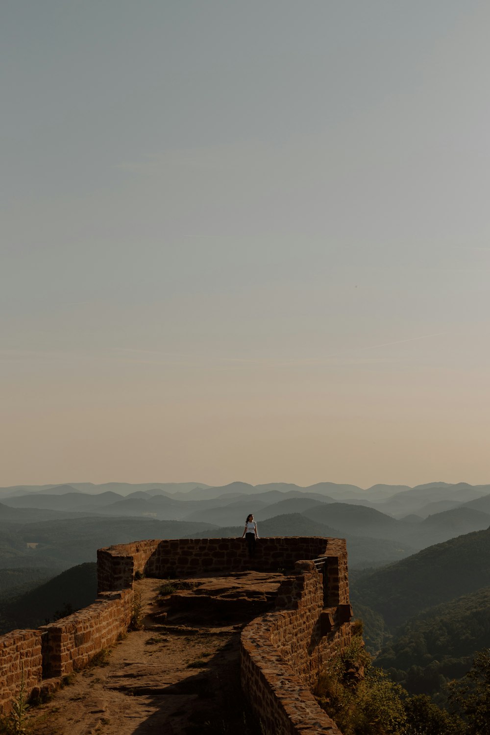 a person standing on top of a stone wall