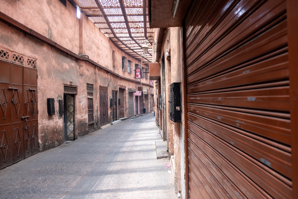 a narrow alley way with closed doors on both sides