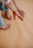 Hands reaching out with bare feet on a peach-colored surface, giving a sense of warmth. The focus is on the interaction between the limbs, creating an intimate and relaxed atmosphere.