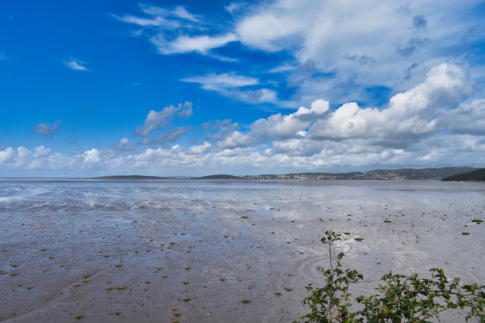 a large body of water sitting under a cloudy blue sky