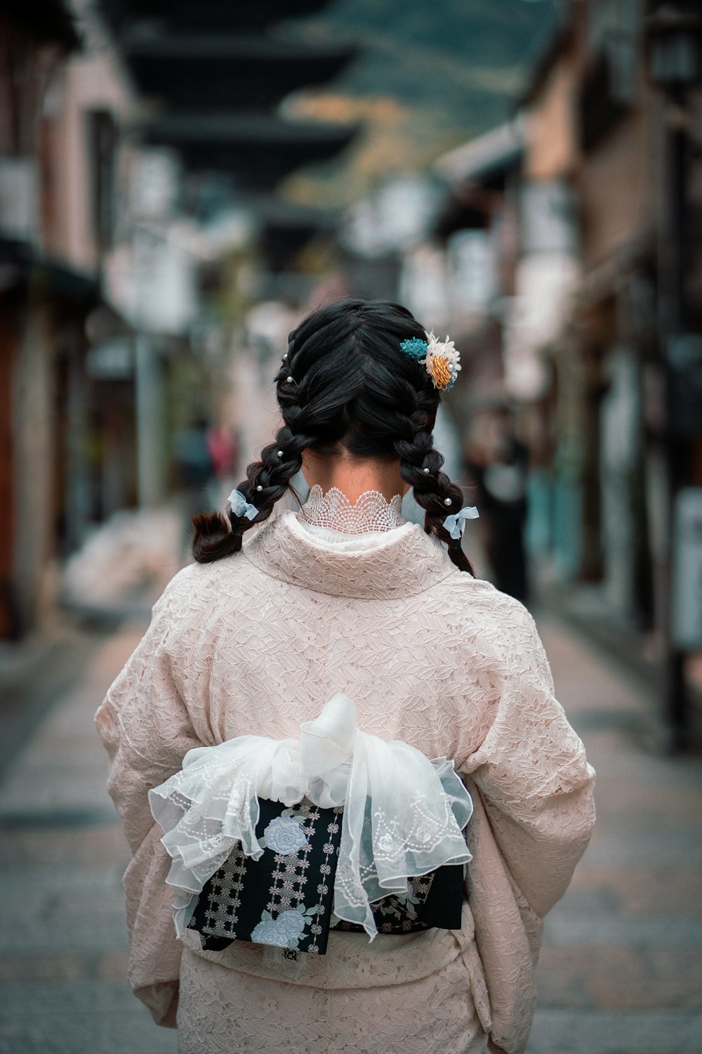 a woman in a kimono walking down a street