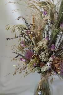 A vibrant bouquet of mixed seasonal flowers in a rustic vase, showcasing rich colors and textures.