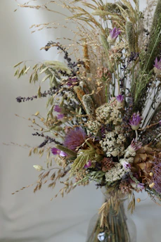 A vibrant bouquet of assorted flowers in a rustic vase, showcasing a mix of colors and textures.