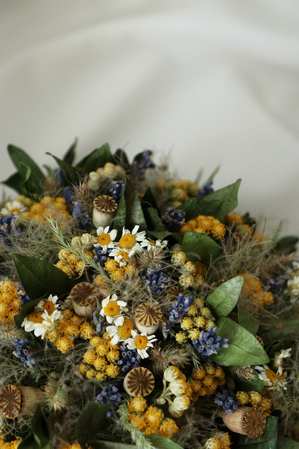 a bouquet of wildflowers and other flowers on a white cloth