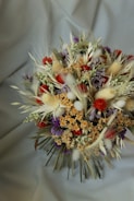 a bouquet of dried flowers on a white cloth