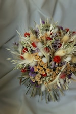a bouquet of dried flowers on a white cloth