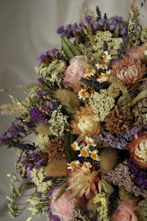 A charming mix of wildflowers and roses in a handcrafted bouquet for weddings.