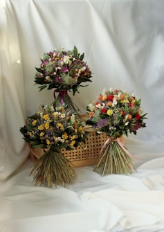 three bouquets of flowers sitting in a basket