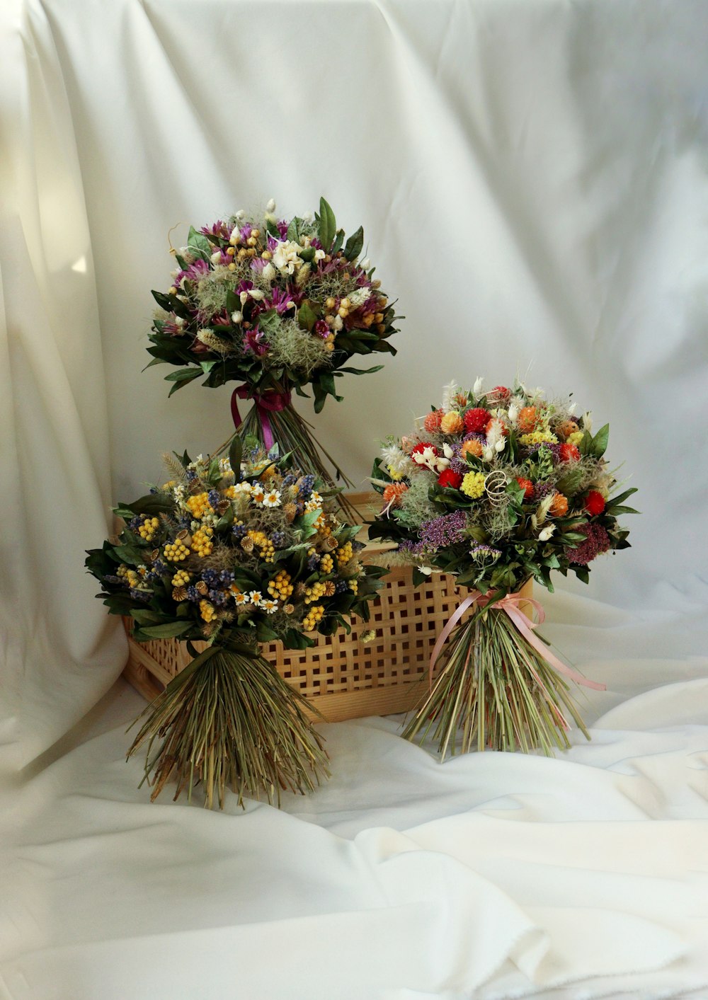 three bouquets of flowers sitting in a basket