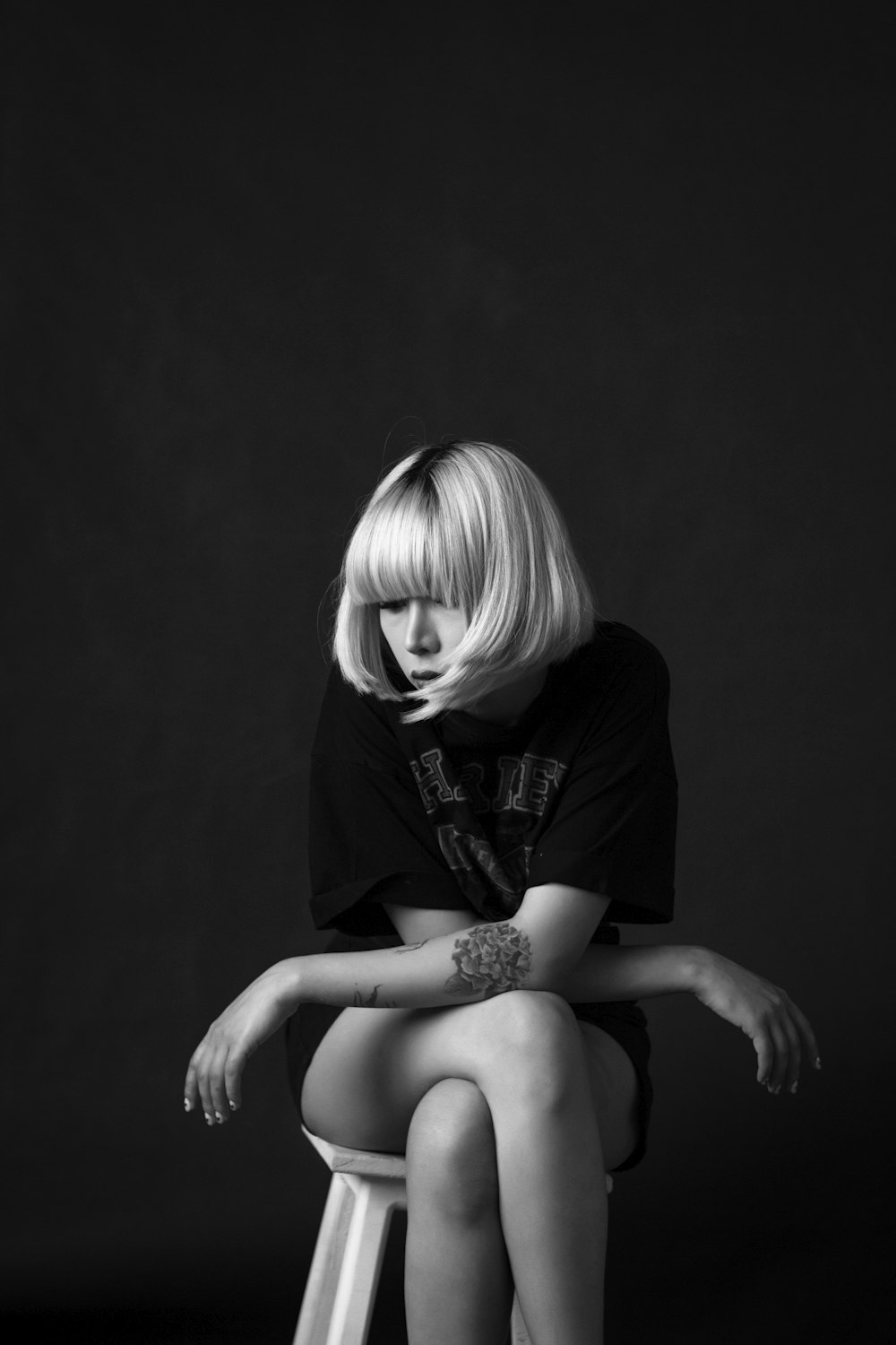 a woman sitting on top of a stool