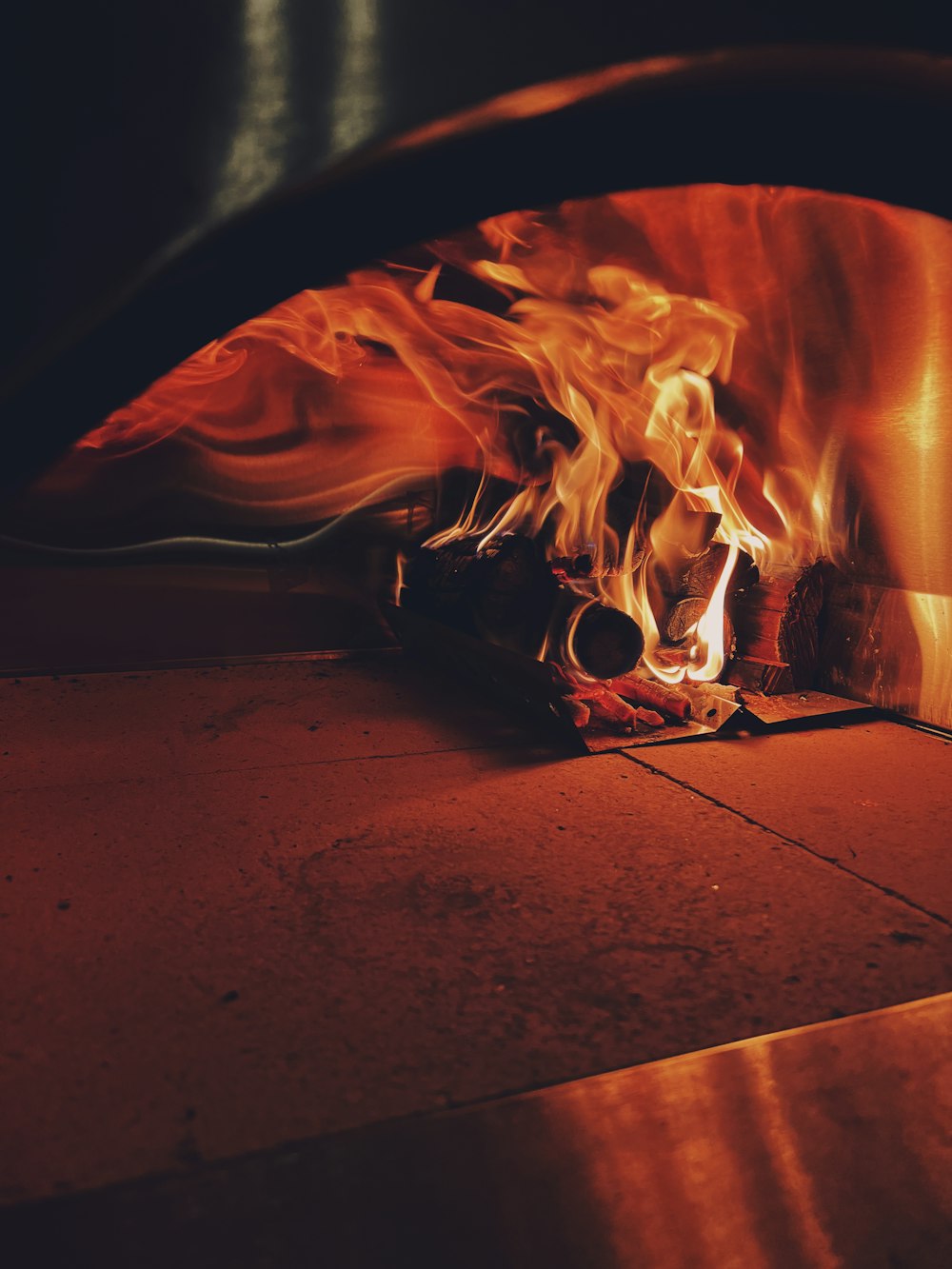 a fire burning inside of a brick oven