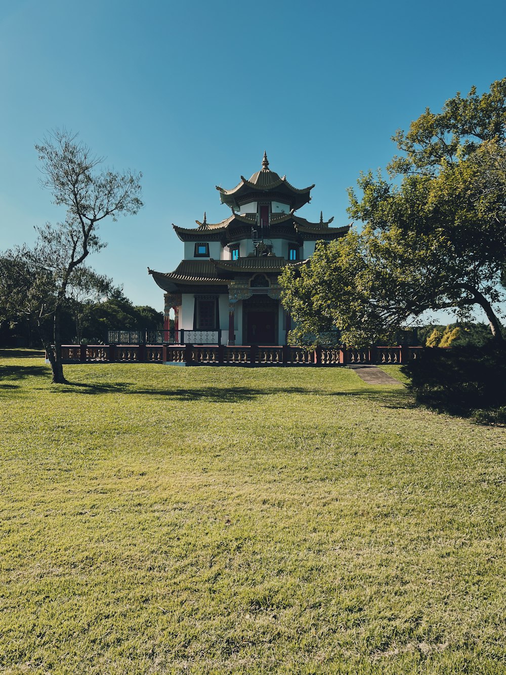 a tall building sitting on top of a lush green field