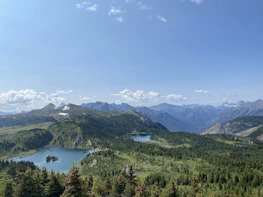 A peaceful mountain view of Kashmir with snow-capped peaks and lush valleys.