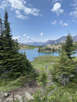 A serene lakeside trail with footprints and a phone screen displaying the retrace labs emergency safety feature.