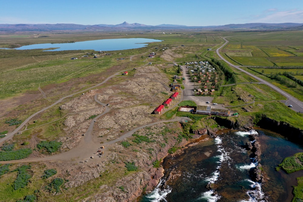 an aerial view of a red train on a track next to a body of water