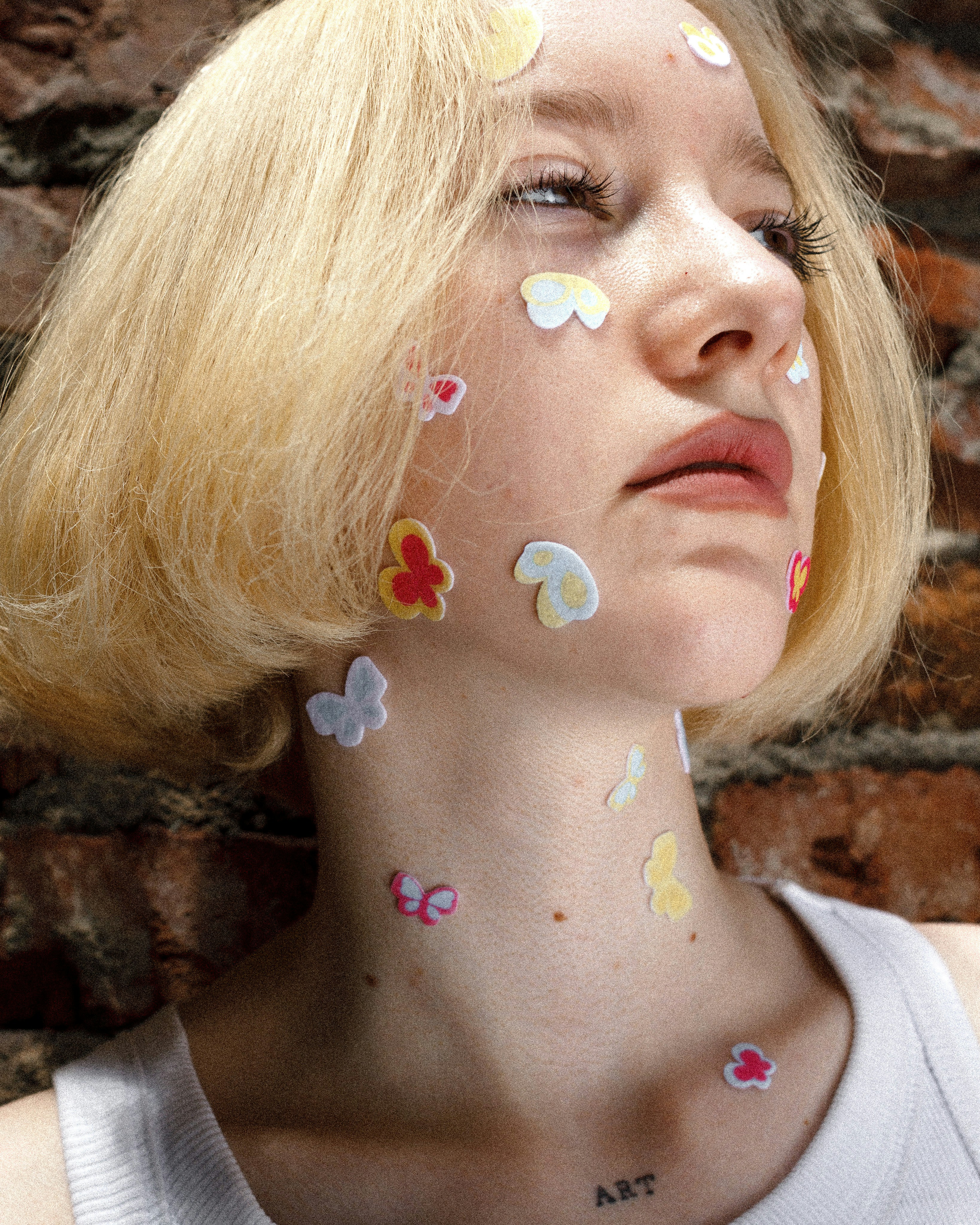 a woman with her face painted with butterflies