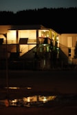 Nighttime exterior shot of a condo building illuminated with tasteful lighting.