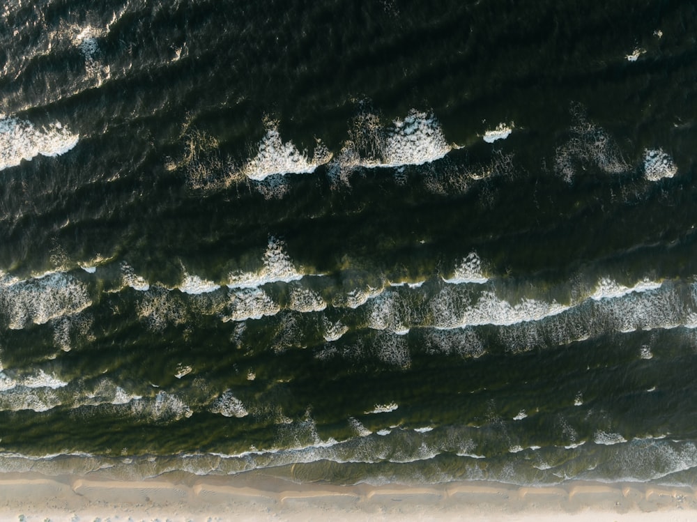 an aerial view of the ocean with waves