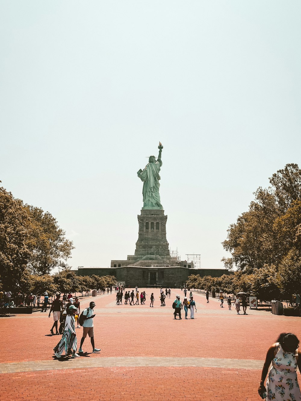 a group of people standing around a statue of liberty