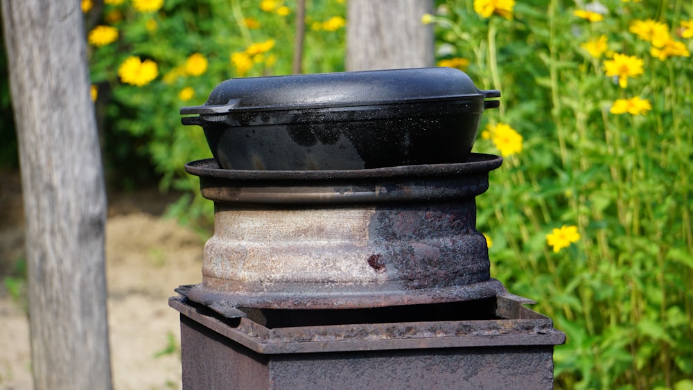 a black trash can sitting on top of a metal pole