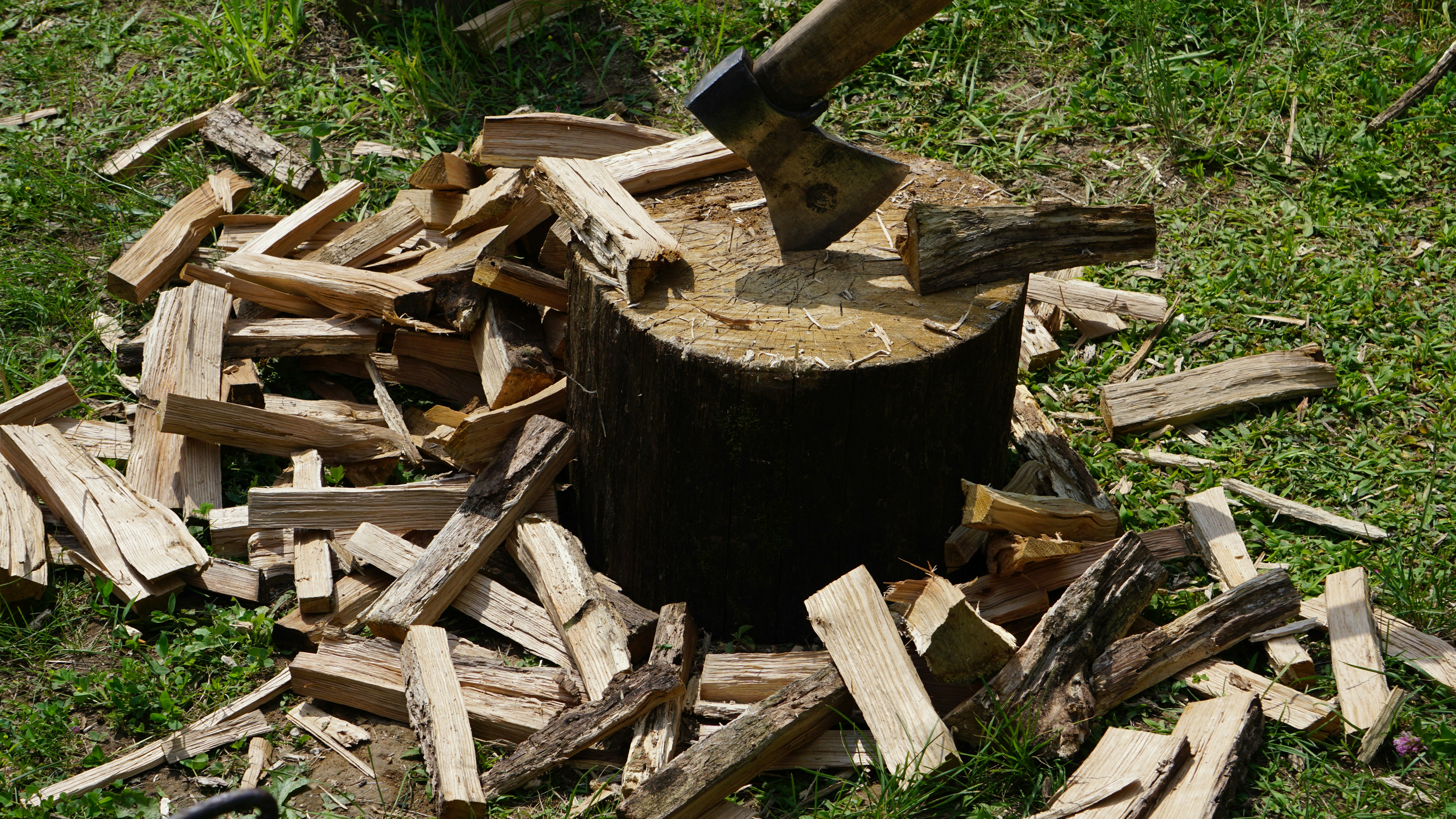 a large axe stuck in a pile of wood