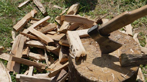 a pile of wood with an axe sticking out of it