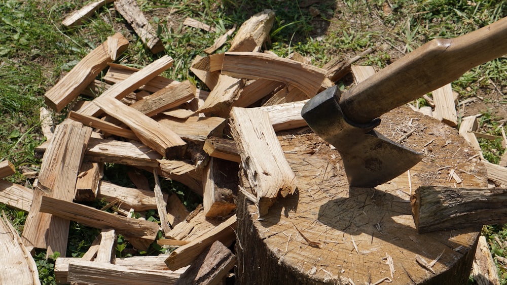 a pile of wood with an axe sticking out of it