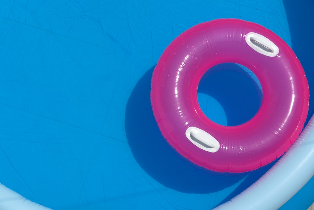 an inflatable swimming pool with a pink ring