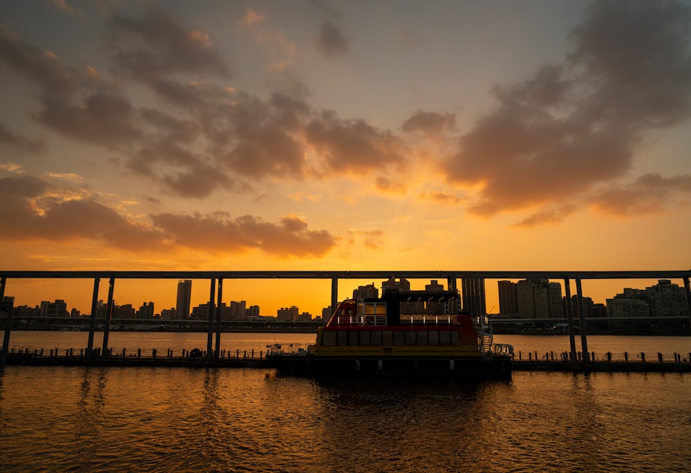 a boat floating on top of a river under a cloudy sky