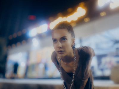 Side profile of Sakujo focused intensely on his equipment during a night set.