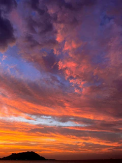 Sunset over the volcanic landscape of Reunion Island with vibrant orange and purple hues
