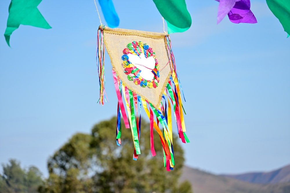 a colorful kite with a bird on it hanging from a line