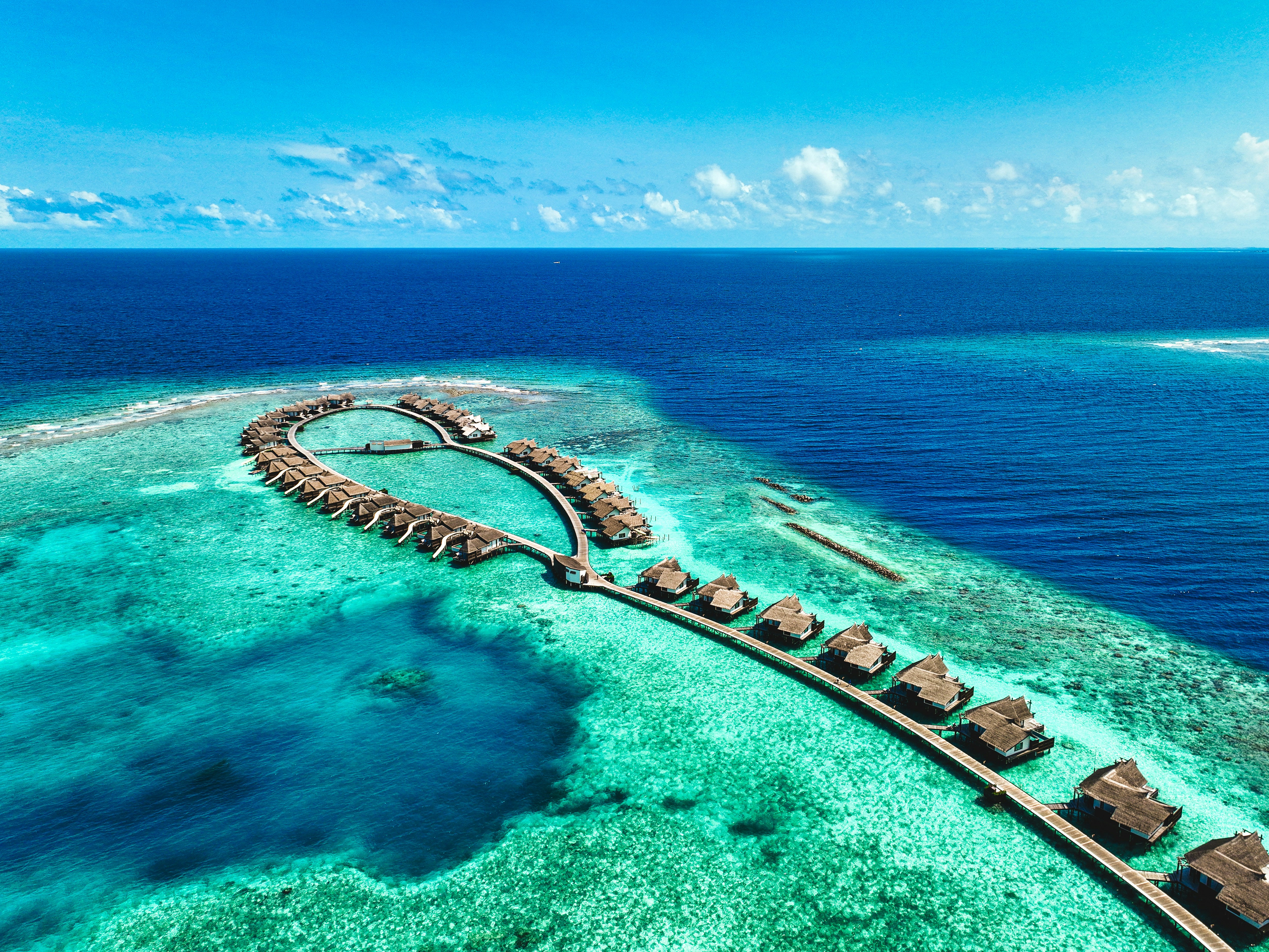an aerial view of a resort in the middle of the ocean, Overwater villas