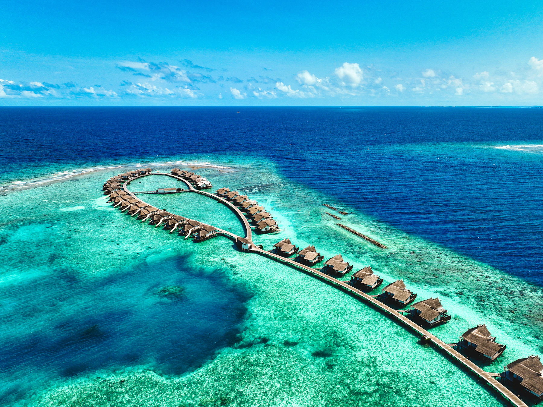 Aerial view of luxury overwater villas surrounded by turquoise ocean in the Maldives