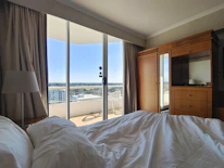 A cozy hotel room with a stunning city view through the window.