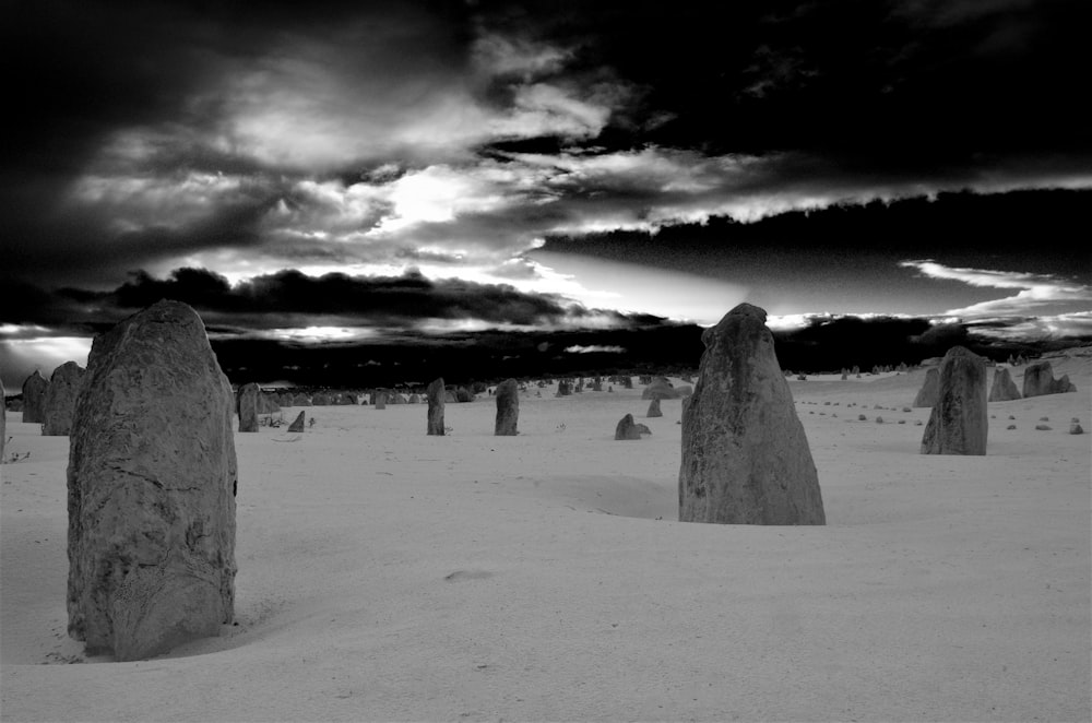 a black and white photo of a group of stones in the snow