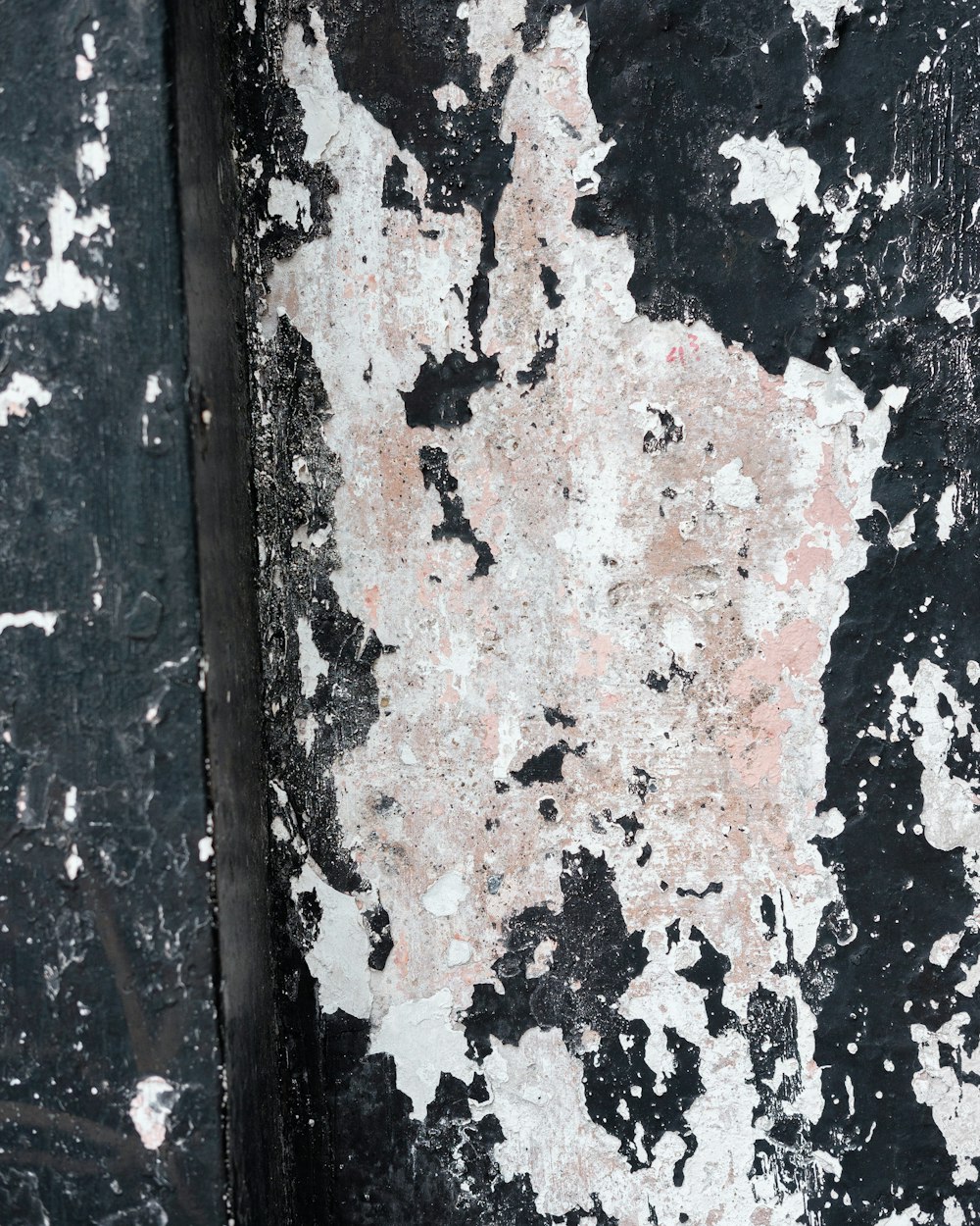 a black and white wall with peeling paint