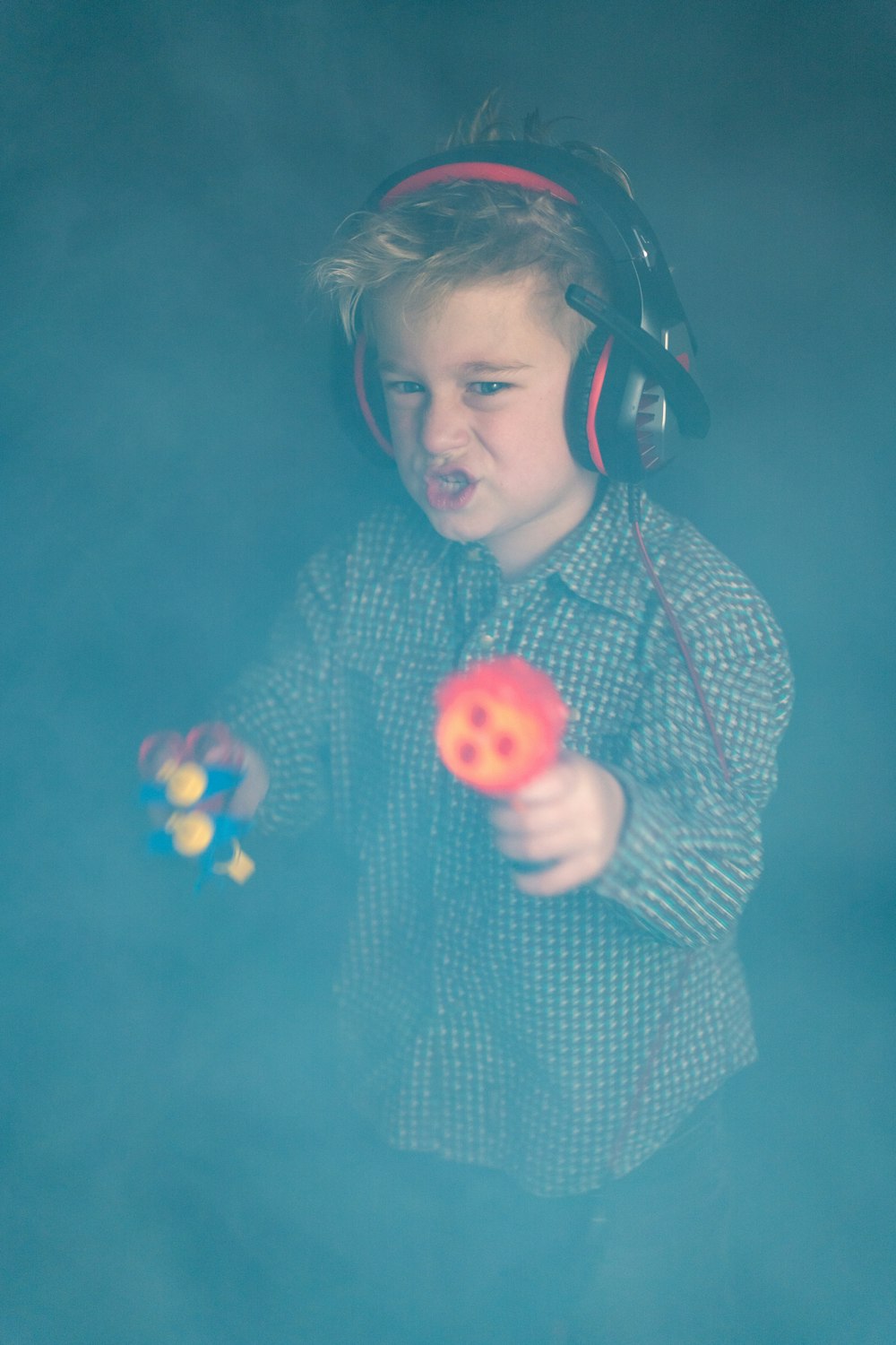 a young boy wearing headphones and holding a ball