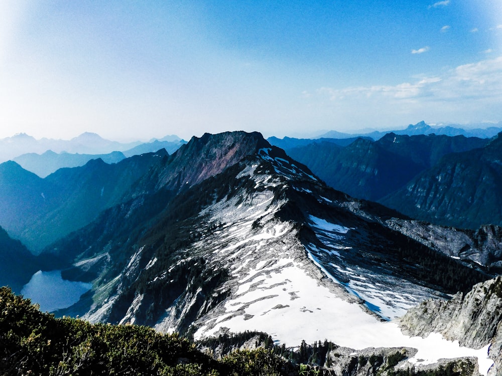 a snow covered mountain with a lake below