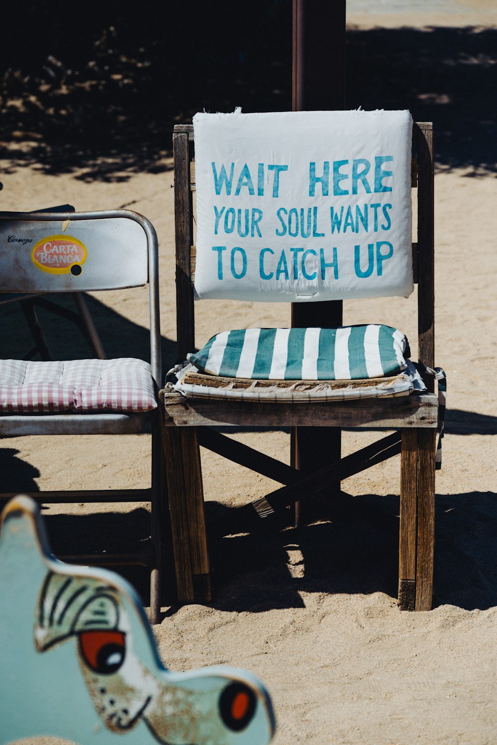 a chair and a sign sitting in the sand