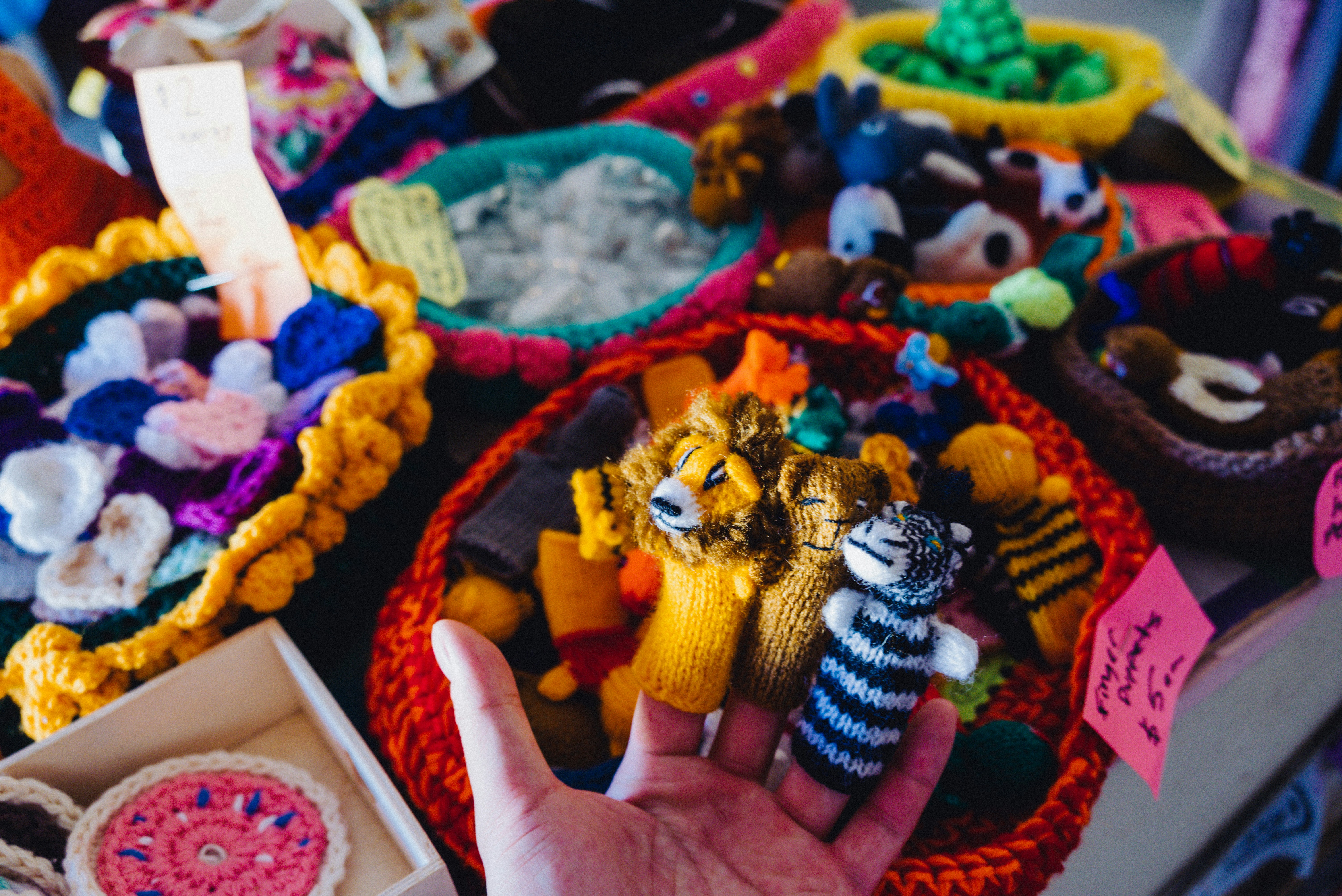 a hand is holding a small stuffed animal