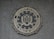 A circular seal of the Federal Bureau of Investigation is set against a textured surface. The seal includes the Department of Justice's name, an eagle, a shield, and the words Fidelity, Bravery, Integrity.