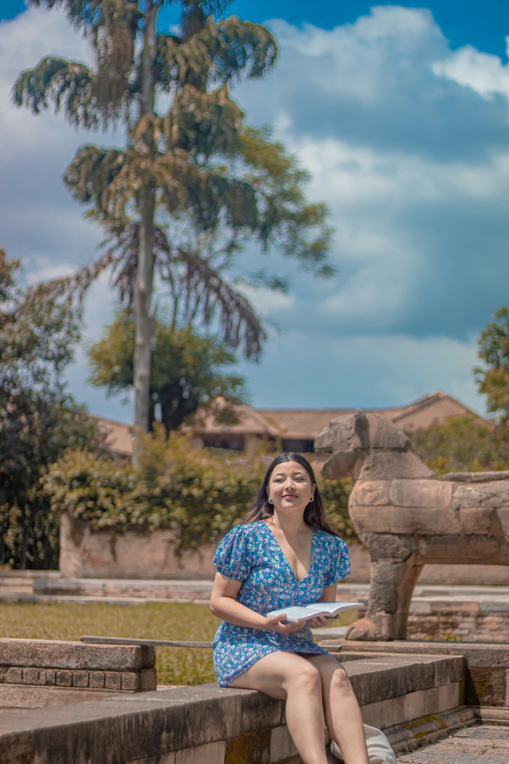 a woman in a blue dress sitting on a bench